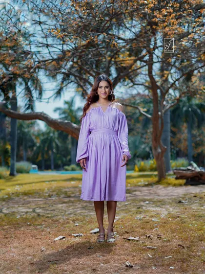 A classic standing portrait that showcases the full dress against a beautiful natural backdrop of trees and soft light.