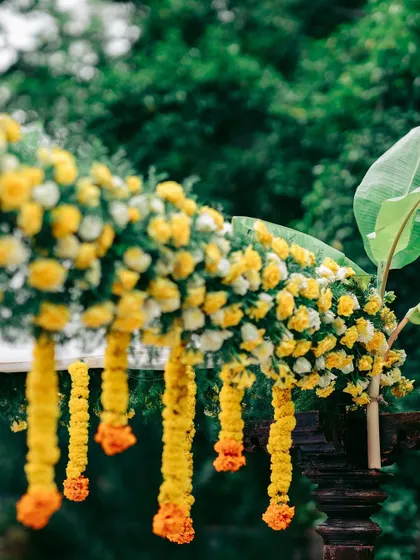 A close-up of the lush floral decor on the mandap, featuring yellow marigolds and auspicious banana leaves.