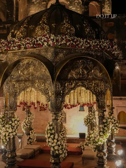An ornate, antique-finish mandap designed for a royal wedding in Khimsar. The structure itself is a work of art, which I adorned with garlands of tuberose and accents of red roses to enhance its grandeur.