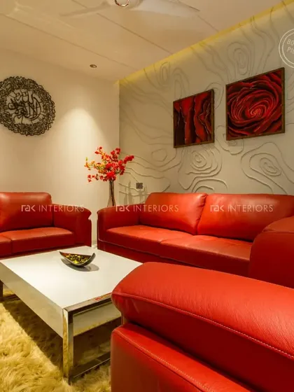 Another bold living room with red leather sofas, this time complemented by a textured wall with a wave pattern and dramatic artwork.