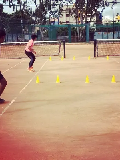 Two players execute a fast-paced agility drill, weaving through cones to improve their reaction time and change-of-direction speed.