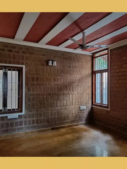 A bedroom with exposed soil cement block walls and a jack arch ceiling, creating a rustic and earthy ambiance.