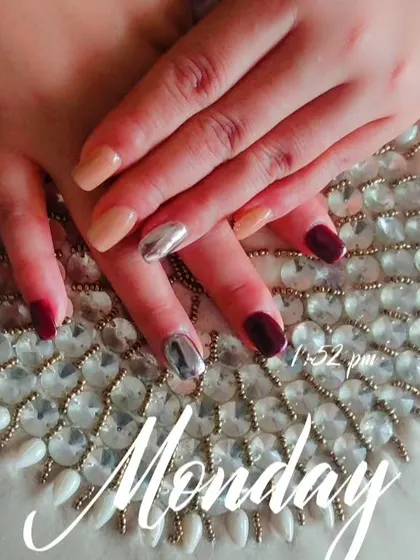 A different view of the manicure with silver chrome accents, showing how it looks against the deep maroon and nude polishes.