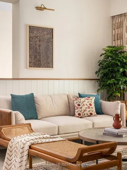We love to blend textures to create warm, inviting living spaces. In the 'Palaash' project, we used a mix of wood, rattan, and soft fabrics to craft a contemporary yet earthy feel. The curved half-wall and custom TV unit with dual-side access add a layer of bespoke functionality and visual softness to the room.