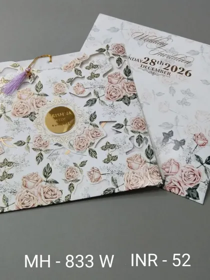 This unique invitation has a laser-cut rose pattern on the cover and a tassel for a decorative touch. The design is intricate and romantic.