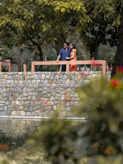 This is a classic outdoor pre-wedding portrait taken at a park in Delhi. I use natural light and scenic elements like this stone bridge to create beautiful, relaxed images for couples.