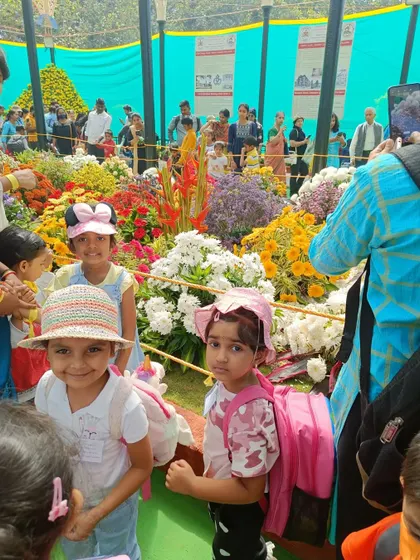 Two children smile for the camera amidst the stunning floral arrangements. The flower show was a perfect opportunity for nature appreciation and photography.