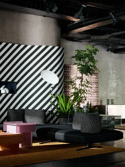Another angle of the striped lounge area, showing how the space is balanced with plants and other textured elements like the woven screen.