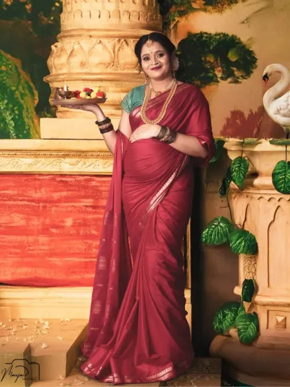 Holding a traditional thali (plate) of offerings, this mama-to-be looks radiant against another one of our artistic, temple-inspired painted backdrops.