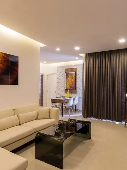 This living room design is clean and contemporary, with a comfortable off-white sofa, a sleek black coffee table, and a statement floor lamp.