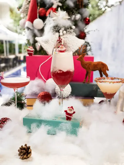 A festive display of our exclusive Christmas cocktails. We craft delightful blends of seasonal flavors, like this layered red drink, to help you celebrate the holiday season in style.