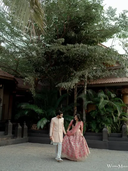 A classic portrait of the couple walking hand-in-hand at their engagement venue. This shot captures the grace and elegance of the occasion.