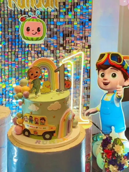 Another view of the Cocomelon cake setup, with a large character cutout standing beside it. I love seeing my creations as part of a full party theme.