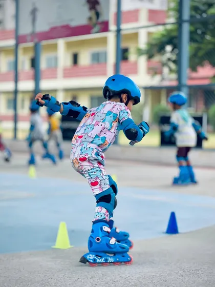 A side view of a young skater practicing his form. Maintaining a low center of gravity is one of the first and most important techniques we teach for stability and speed in roller skating.