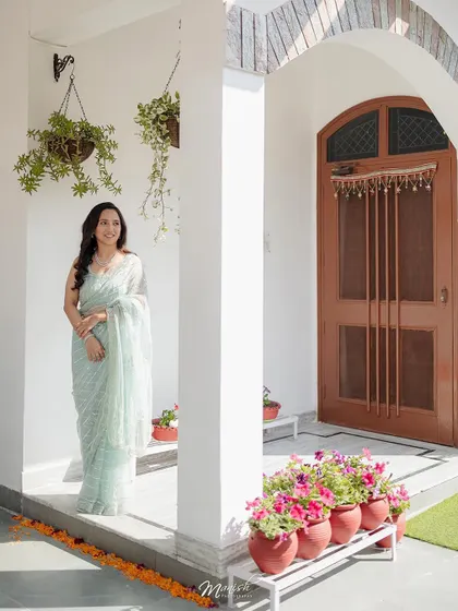 A full-length shot of the bride-to-be at her home, the beautiful flowers and decor adding to the celebratory feel of the Roka.