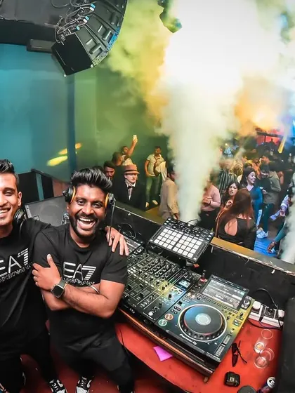 Behind the decks with my partner in crime. The smiles are genuine because we truly love what we do, and that energy translates to the dance floor.