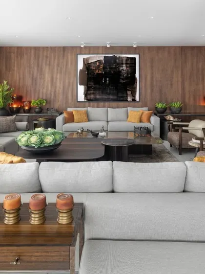 A wide view of the Camellias living room, demonstrating how we use furniture to define space. The L-shaped sofa carves out a cozy corner, while the arrangement of armchairs and console tables creates a sense of balance and flow, leading the eye towards the art and windows.