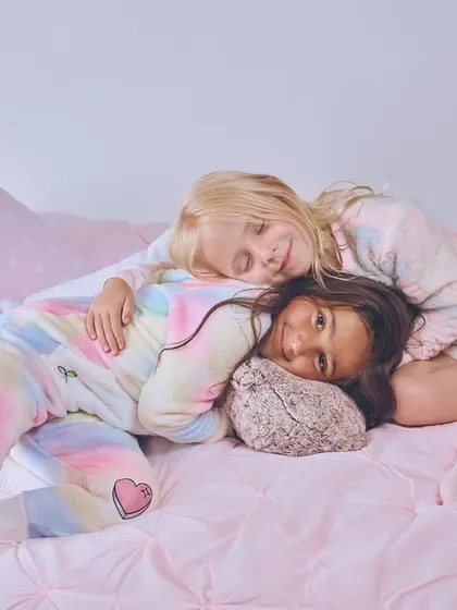 A sweet and peaceful shot for a kids' sleepwear line. The soft lighting and pastel colors create a calm and dreamy mood.