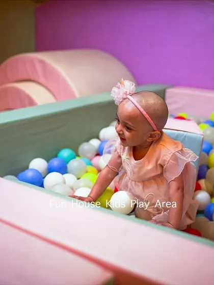 A baby safely enjoying the colorful ball pit in our pastel play area. The soft walls and clean balls make it perfect for crawlers.