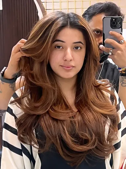 A client showing off her new "Millionaire" haircut. The layers are styled to create maximum volume and a glamorous, windswept look.