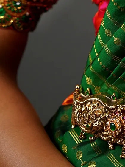 A close-up of the armlet (vanki) and the border of the silk blouse. Every detail, down to the accessories, is part of the overall bridal styling.