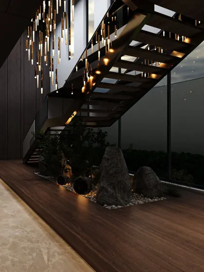 The dark wood of the staircase and wall paneling creates a moody and sophisticated backdrop for the indoor garden. The warm, integrated lighting highlights the textures of the rocks and plants, making it a captivating feature day and night.