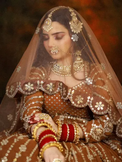 A warm, earthy-toned bridal look with a brown lehenga, perfect for an autumn wedding.