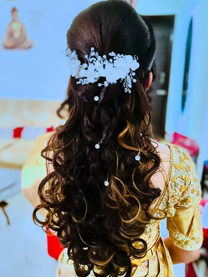 A beautiful reception hairstyle with soft curls and a delicate white hair accessory. This is a popular choice for brides who want a romantic and modern look.