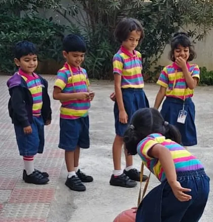 Students wait for their turn to play, learning patience and sportsmanship while cheering on their friends.