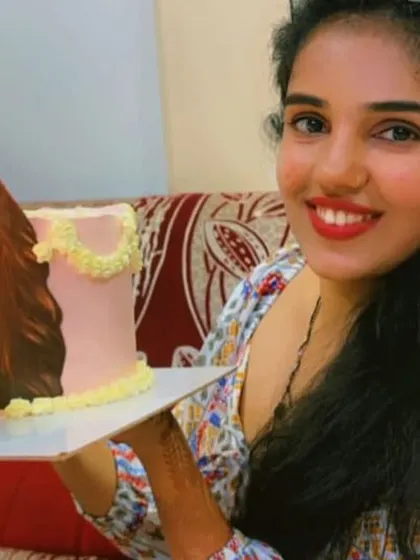 A close-up of our happy client and her unique blow-out cake.
