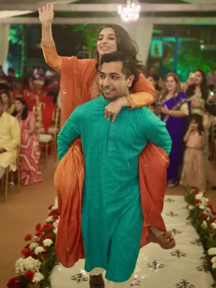 The bride enjoys a piggyback ride from her brother, a fun and candid moment from the Janya ceremony.
