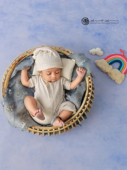 A top down view of the rainbow theme, showing the baby peacefully sleeping under a sky blue backdrop with a little cloud and rainbow.