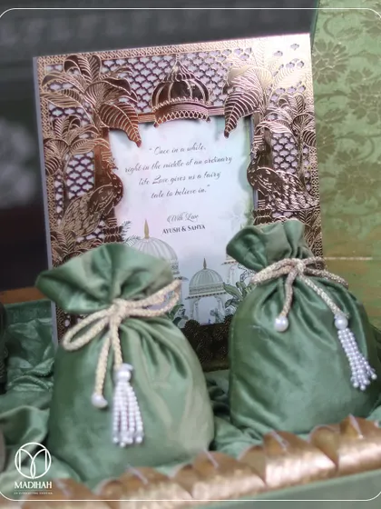 A closer look at the details. This close-up shows the intricate brass work on the invitation frame and the soft, luxurious texture of the velvet potlis, key elements of my bespoke wedding hampers.