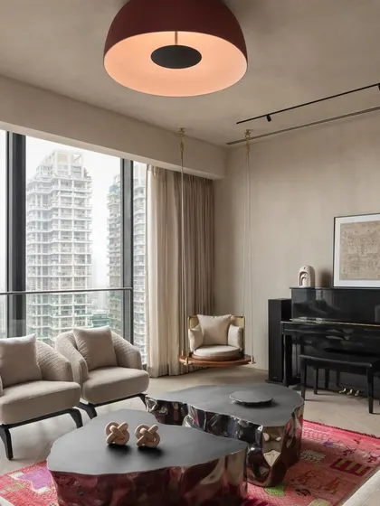 For the East Coast Residence, we created a dynamic living space with a view. The unique, metallic-finish coffee tables contrast with the soft textures of the rug and seating, while a playful swing adds a personal touch.