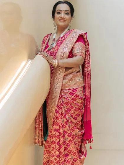 A solo portrait showcasing the beauty of this custom pink Bandhani saree. The piece is adorned with dabka, resham, and zardosi work, paired with a matching hand-embroidered dupatta.
