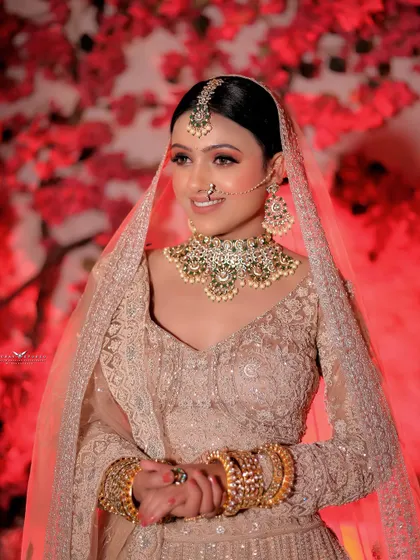 A bright and happy portrait against a red floral backdrop. The bride's smile and direct gaze create a joyful and engaging image that showcases her modern bridal look.