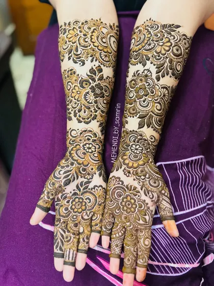 A full and festive design for a beautiful client's 'baat pakki' ceremony. This style combines dense floral work with traditional patterns, covering both hands and extending up the arms for a stunning celebratory look.