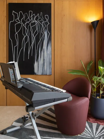 You don't have to be traditional just because you have a classic element like a keyboard. This music room pairs it with modern art and a bold red armchair for a cool, eclectic vibe.