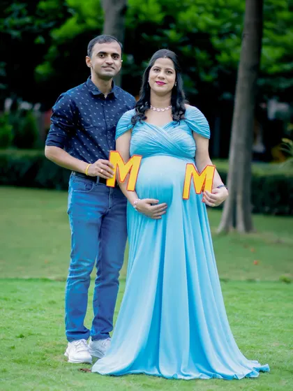 A fun prop for the mom-to-be! This couple's portrait in the park is playful and full of joy.