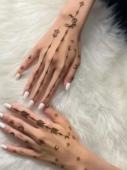 Delicate chains of moons and stars adorn the back of the hands in this elegant design. It's a subtle and chic way to get into the festive spirit.