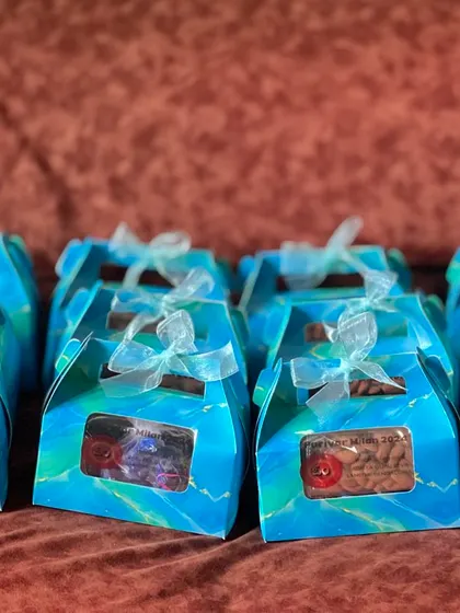 Another angle of the blue favor boxes, tied with delicate white ribbons. The presentation is clean, simple, and elegant.