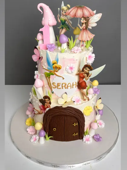 We built a tiny, enchanting world for this two-tiered fairy house cake. It features multiple hand-painted fairy figurines, sculpted mushrooms, and a detailed wooden door, all designed to capture the magic of a childhood storybook.