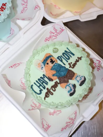 This teddy bear bento cake celebrates the "Champion of our times." The sporty teddy is ready to play, making it a perfect cake for a dad who loves sports.