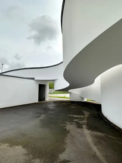The undulating forms of Gehry's Vitra building. It is a spatially rich and intriguing work that shows the influence of early modernism while hinting at the deconstructed forms he would later become famous for.