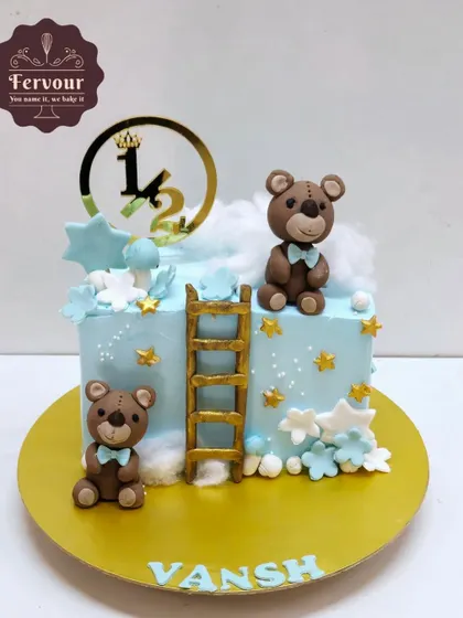 A sweet teddy bear-themed cake for a half-birthday. The design features two cute bears, a ladder, and stars, all on a soft blue whipped cream cake.