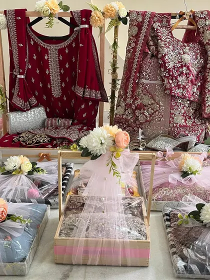 A grand display of wedding trousseau gifts. We use standing displays for bridal lehengas and coordinated baskets for other items, ensuring a magnificent presentation.