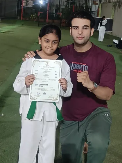 Congratulating another student on achieving her next belt level. Her hard work and dedication have paid off.