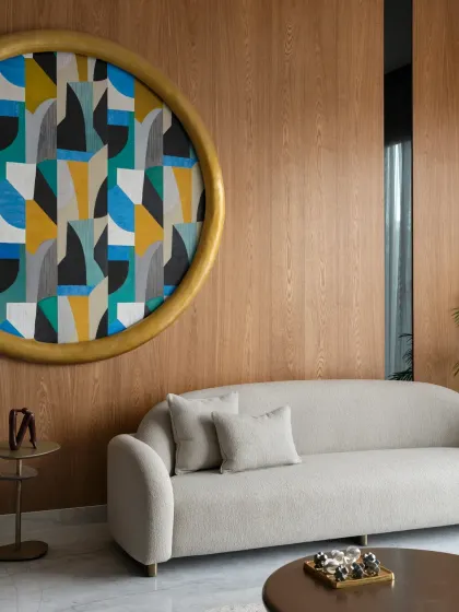 This magnificent six-foot round painting is the main attraction in the drawing room of The House of Dancing Screens. The room's neutral decor provides a sophisticated background, allowing the colorful, geometric artwork to make a bold statement.