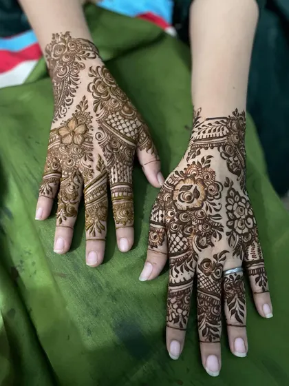Here you can see two different but complementary designs on each hand. One hand has a floral focus while the other uses more geometric patterns, showing how we can mix styles.