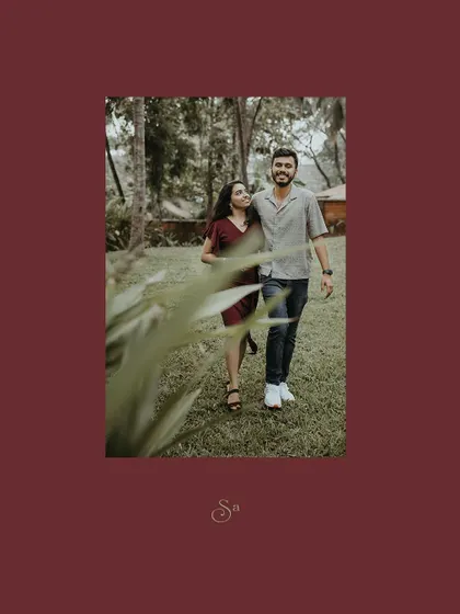 A candid shot of a couple walking and smiling in a park, framed in a warm red border.